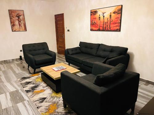 sala de estar con sofá y 2 sillas en Appartements meublés - Cozy House Bénin en Cotonú