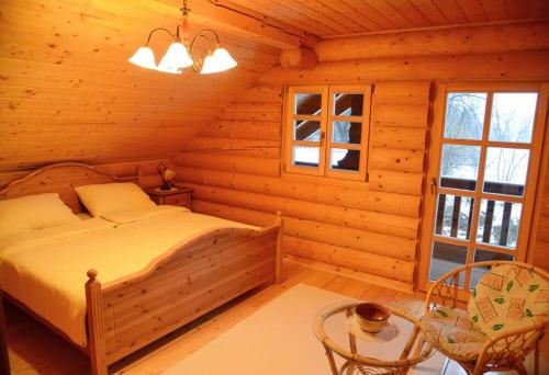 ein Schlafzimmer mit einem Bett in einem Blockhaus in der Unterkunft Luxury Chalet at Podlipje Estate 