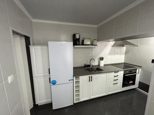 a kitchen with a white refrigerator in a room at Silva House Refuge in Algarvia