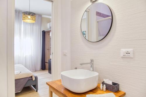 a bathroom with a large white sink and a mirror at Medea Mondello Suite in Mondello