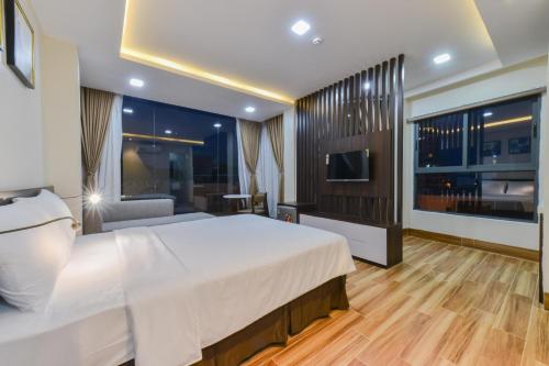 a hotel room with a bed and a television at Yen Vang Hotel & Apartment Nha Trang in Nha Trang