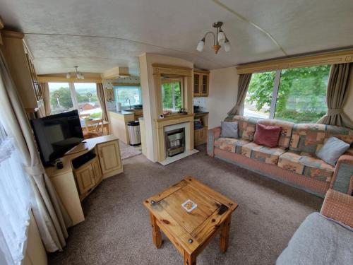 a living room with a couch and a table at Caravan F7 Aberystwyth holiday village in Aberystwyth