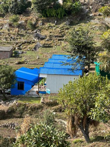 a building with a blue roof on a hill at Lake Haven Resort, Sari, Chopta in Sari