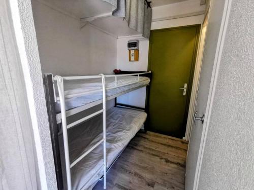 Ce lit superposé se trouve dans une petite chambre dotée d'une porte verte. dans l'établissement 024 Gabiers A24, au Cap d'Agde