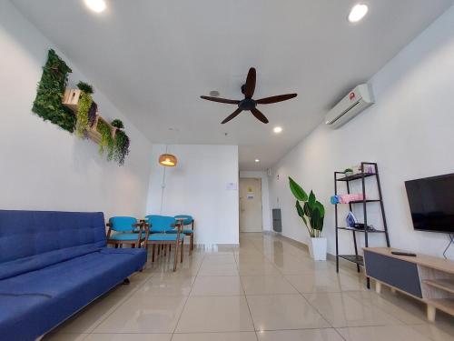 a living room with a blue couch and a ceiling fan at 3 Elements* The Garden* MRT2* Wifi* Self Check-In in Kampong Batu Sembilan