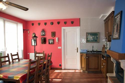 comedor con mesa y pared roja en Habitaciones Turísticas Ontxene, en Busturia