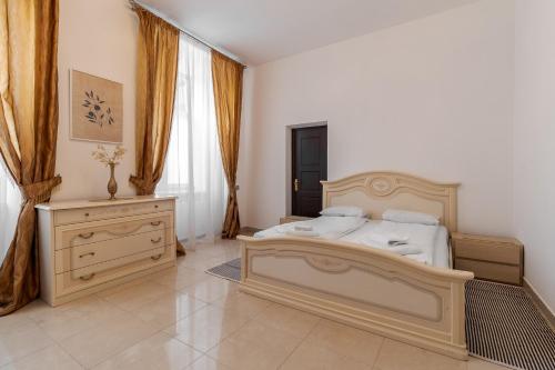 a bedroom with a large bed and a dresser at Апартаменти на Площі Ринок, 20 in Lviv
