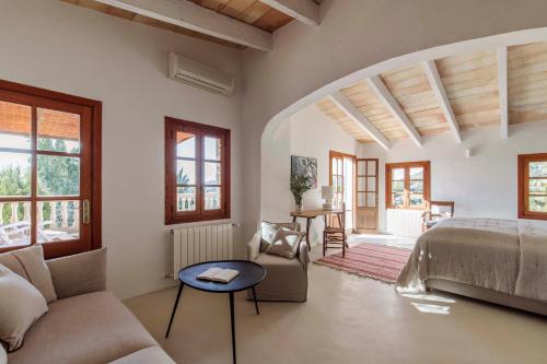 a bedroom with a bed and a couch and a table at C'an Talaieta Luxurious Farmhouse in S'Horta