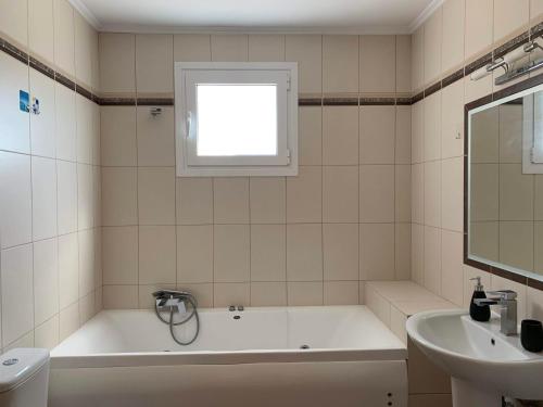 a white bathroom with a tub and a sink at Sea melodies apartment 1 in Koroni
