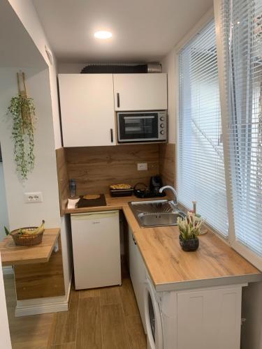 una pequeña cocina con fregadero y microondas en Tirana Apartment, en Tirana