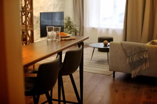 uma sala de estar com uma mesa de madeira e cadeiras em Town Hall Square Apartment em Taline