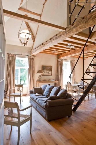 a living room with a couch and a staircase at Lozerkasteel in Kruishoutem