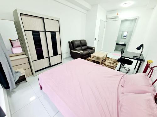 - une chambre avec un lit rose et une chaise dans l'établissement Sky tren service apartment, à Johor Bahru