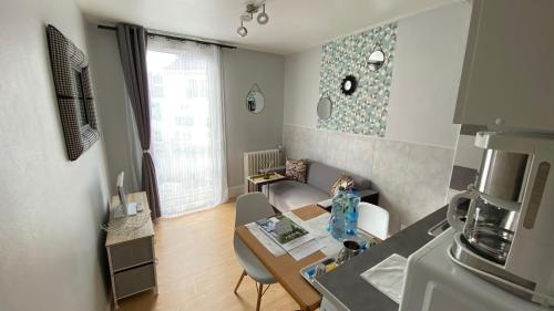 Il comprend un petit salon avec une table et une cuisine. dans l'établissement Résidence des Sources, à Vichy