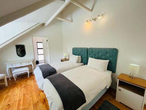 1 dormitorio con 2 camas y escritorio en Summerhill Self-Catering Accommodation St Francis Bay, en St Francis Bay