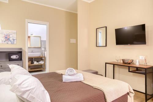 a bedroom with a bed with a tv on the wall at Medea Mondello Holiday in Mondello