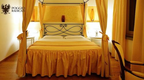a bedroom with a canopy bed with an orange bedspread at Poggio Radicati Hotel De Charme in Saluzzo