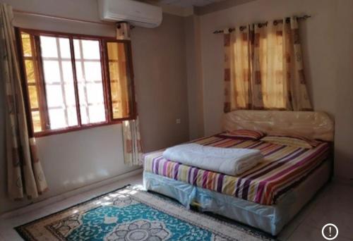 a small bedroom with a bed and a window at Rahalt alsharq in Ibrā