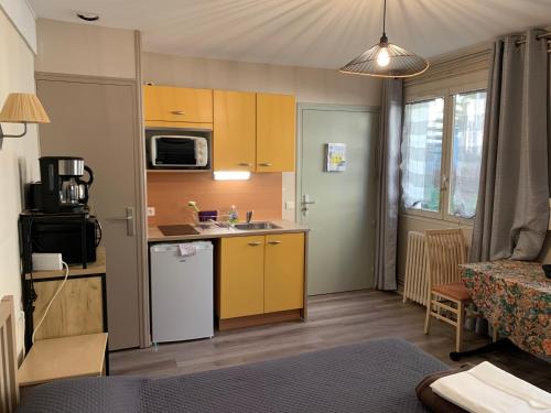 une petite cuisine avec un évier et un réfrigérateur dans l'établissement Résidence Le Rochebonne, à Saint-Malo