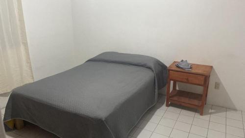 1 dormitorio con 1 cama y mesita de noche junto a la cama Sidx sidx sidx sidx en Cómodo departamento en Naciones unidas, en Guadalajara