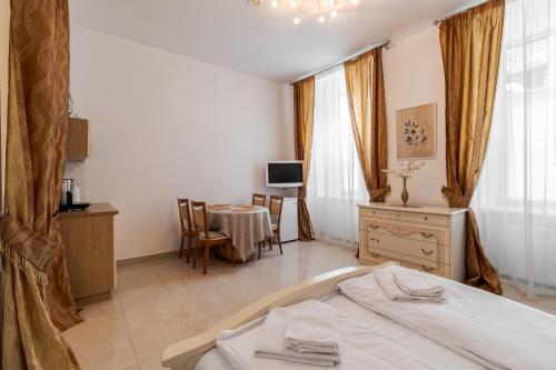 a bedroom with a bed and a table and a television at Апартаменти на Площі Ринок, 20 in Lviv