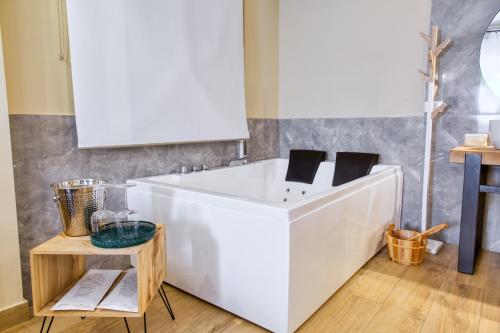 a white bath tub in a room with a table at Medea Mondello Holiday in Mondello