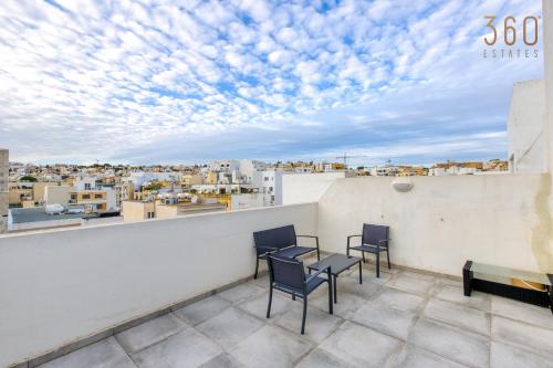 a balcony with a table and chairs and a view of the city at A fully equipped 3BR penthouse with large terrace by 360 Estates in Il-Gżira