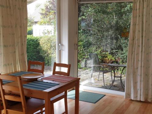 a dining room with a table and chairs and a sliding glass door at Deichgräfin 1 in Horumersiel