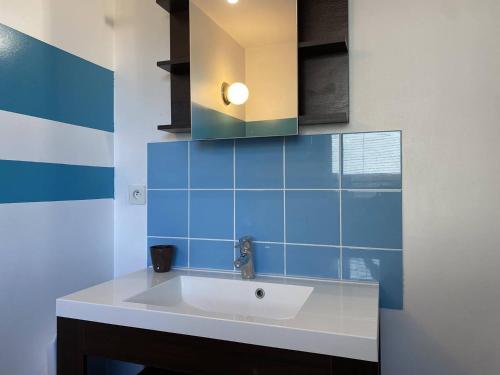 a bathroom with a sink and a blue tile wall at 213 - Charmante maison en bois à moins de 2km de la plage de Sables-D'or-Les-Pins in Plurien