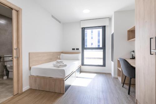 a small bedroom with a bed and a desk at Micampus Getafe II Student Residence in Getafe