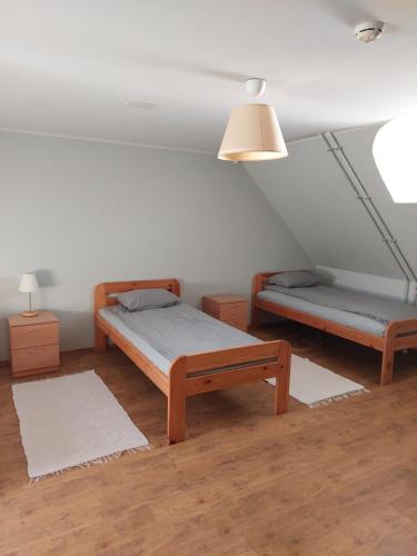 1 dormitorio con 2 camas y 2 mesitas de noche en Rogosi mõisa apartment, en Ruusmäe