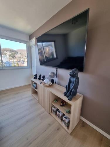 d'un salon avec une télévision à écran plat et une statue d'ours. dans l'établissement Le Landouzy #Parking#Netflix, à Chamalières