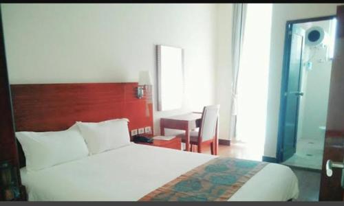 1 dormitorio con 1 cama y 1 mesa con silla en Armah International Hotel, en Āksum