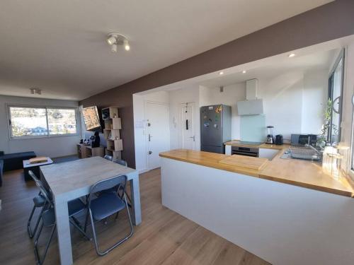a kitchen with a table and a counter top at Le Landouzy #Parking#Netflix in Chamalières