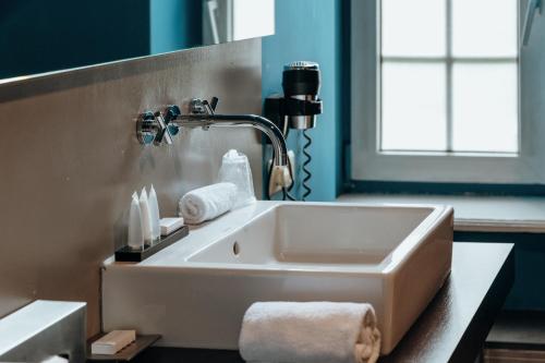 a white sink in a bathroom with a window at Charl's in Knokke-Heist