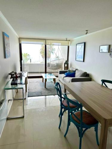 een woonkamer met een bank en een tafel bij Departamento Primera Línea Av. Del Mar La Serena in Coquimbo