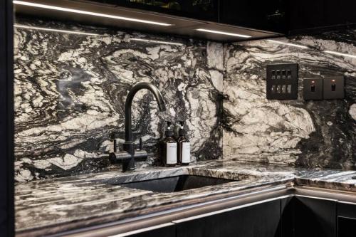 a kitchen with a sink and a stone wall at Unique 1 Bedroom Luxury Haven In Central London in London