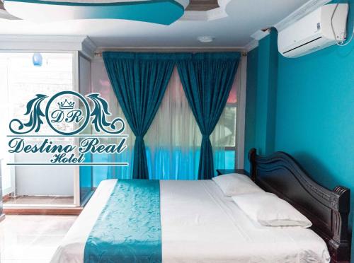 Un dormitorio con una cama con paredes azules y una ventana en Destino real hotel, en Arauca