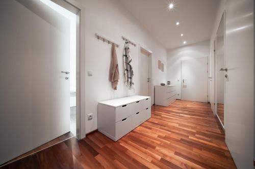um quarto com paredes brancas e piso em madeira em CityFlat 38 Schladming by globboard em Schladming