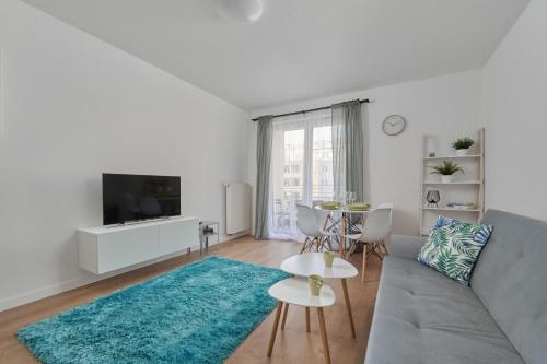 a living room with a couch and a tv at Cozy Apartment Klimasa with Balcony in Wrocław by Renters in Wrocław