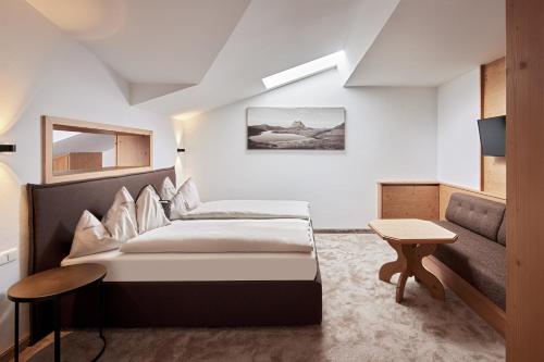 a hotel room with a bed and a couch at Habachklause Familien Bauernhof Resort in Bramberg am Wildkogel