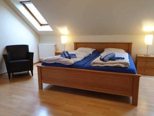 a bedroom with a bed with blue sheets and a chair at Ferienhaus Jantje Moe 4 in Horumersiel