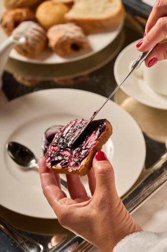 Eine Person hält ein Stück Essen auf einem Teller. in der Unterkunft Loly Boutique Hotel Roma in Rom