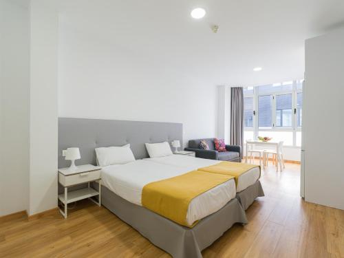 ein Schlafzimmer mit großem Bett und ein Wohnzimmer in der Unterkunft Ok Las Canteras Beach by CanariasGetaway in Guanarteme