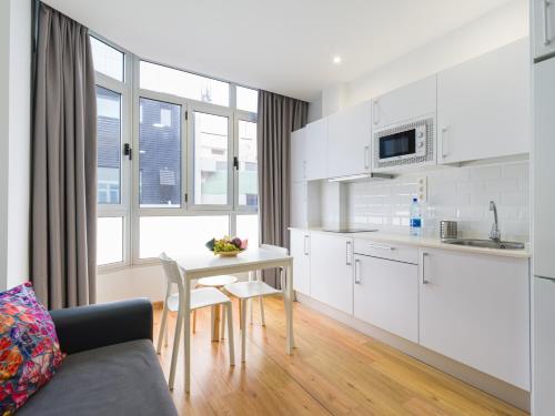 a kitchen and living room with a table and a couch at Ok Las Canteras Beach by CanariasGetaway in Las Palmas de Gran Canaria