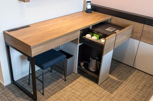 a wooden desk with a blue stool under it at Rooms at Podlipje Estate 