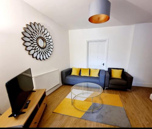 a living room with a blue couch and a table at Stylish 2 Bedroom Apartment Sleeps 5 - 3 mins walk to Mile End Station in London