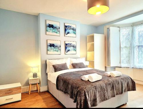 a bedroom with a bed with two towels on it at Stylish 2 Bedroom Apartment Sleeps 5 - 3 mins walk to Mile End Station in London