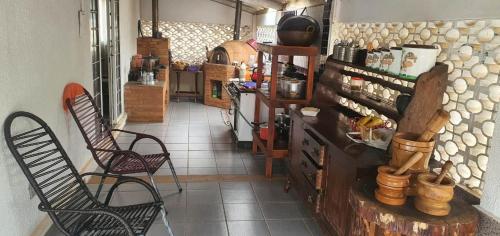 a room with two chairs and a counter in a store at Chácara Cuesta Machado in Botucatu