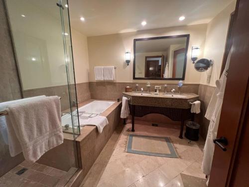 a bathroom with a tub and a sink and a shower at Royal Arabian Stylish Chalets in Four Seasons Resort - By Royal Vacations in Sharm El Sheikh